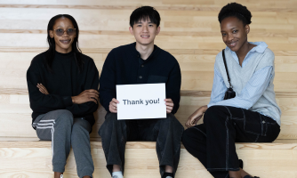Students hold up a piece of paper that reads Thank You