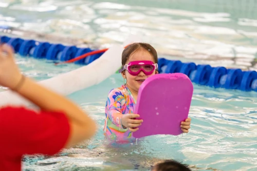 A child swims with a floatation device